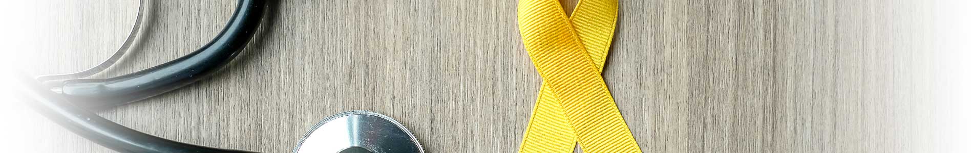 Yellow ribbon representing suicide awareness and prevention next to black stethoscope on table